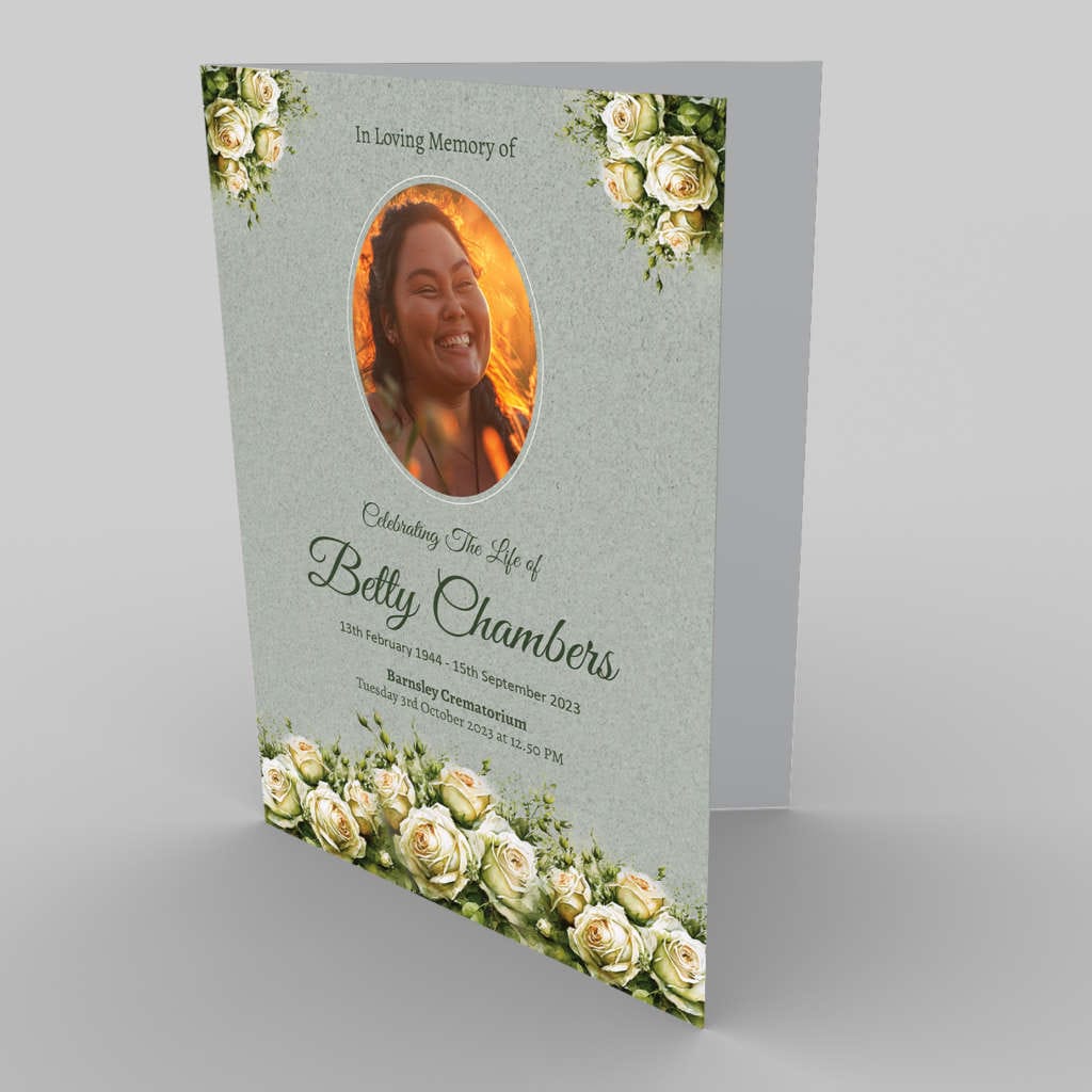 A memorial card featuring a tribute to Betty Chambers, with her photo surrounded by 2.7.2 White Rose and Green flowers, commemorating her life from 1944-2023.